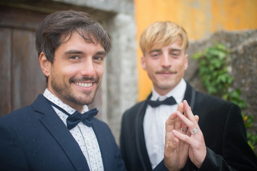 Two Men Holding Hands and Showing their Wedding Rings