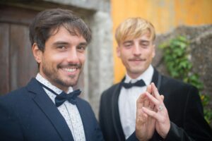 Two Men Holding Hands and Showing their Wedding Rings
